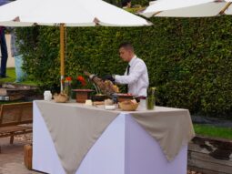Chef carving premium ham at Taste Corner’s elegant rooftop station during a corporate event in South Florida