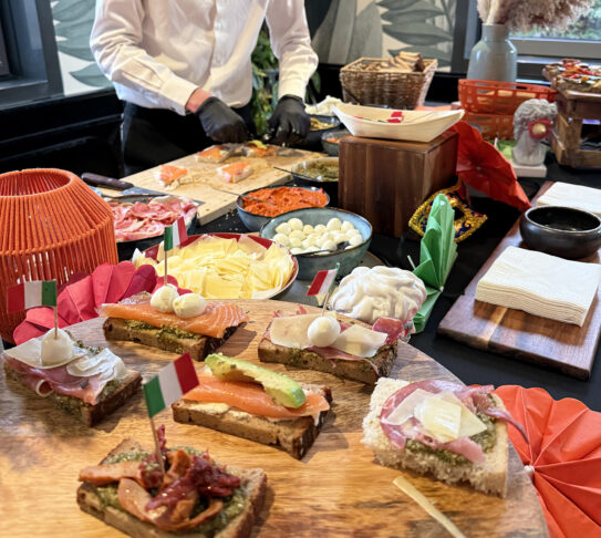 Chef preparing Italian bruschettas with assorted toppings at Taste Corner event in South Florida