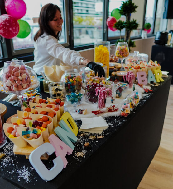 Candy station with host handing out sweets at Taste Corner’s scenographic Christmas buffet during a festive event in South Florida