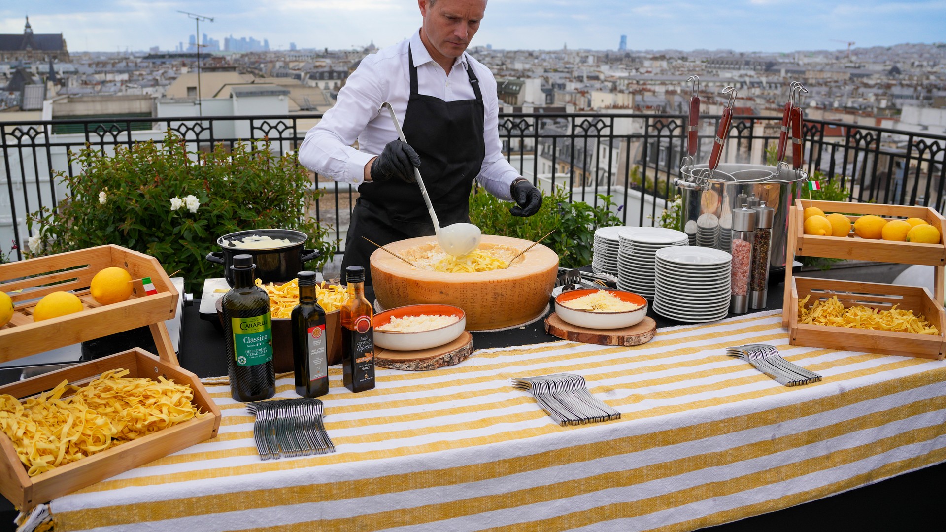 Chef preparing pasta in a parmesan wheel with Italian scenography at Taste Corner’s live station in South Florida