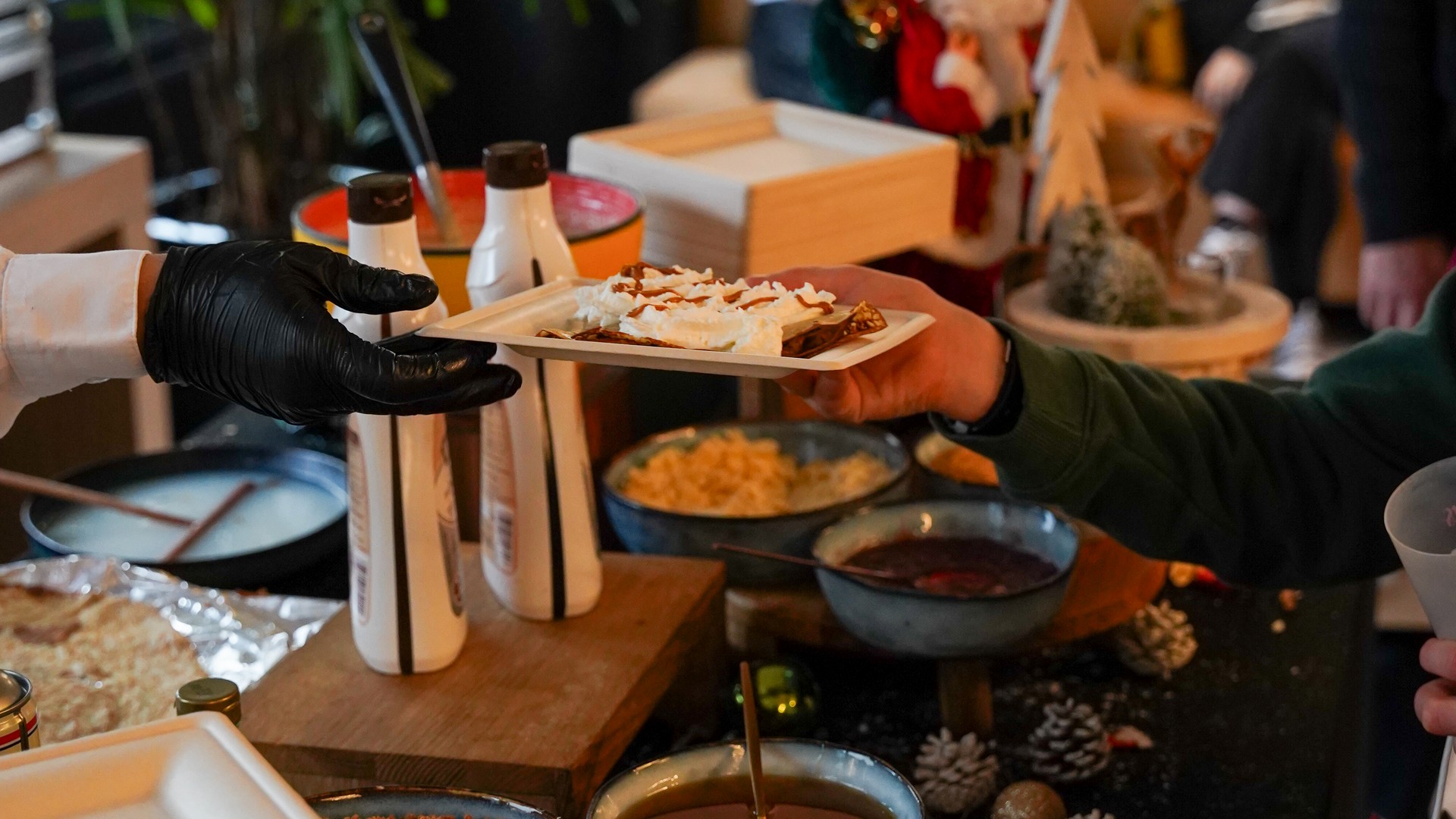 Chef handing a gourmet crêpe topped with whipped cream to a guest at Taste Corner’s scenographic station in South Florida