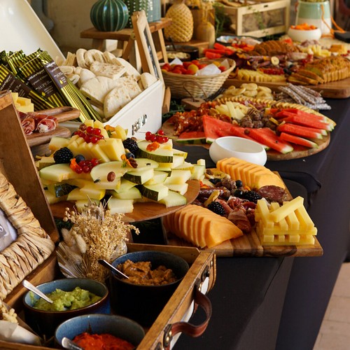 Spring grazing table with charcuterie, cheeses, fruits, cakes, and seeds at Taste Corner’s catered event in South Florida
