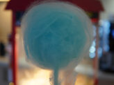 Guest holding a blue cotton candy at Taste Corner’s scenographic station during a festive event in South Florida