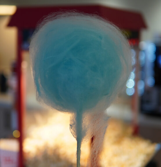 cotton-candy-blue-guest-festive-event-catering-miami Guest holding a blue cotton candy at Taste Corner’s scenographic station during a festive event in South Florida
