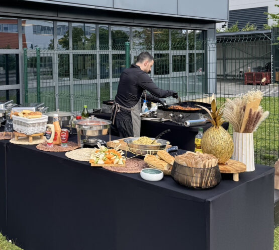 Chef grilling assorted meats at Taste Corner’s outdoor BBQ station during a catered event in South Florida