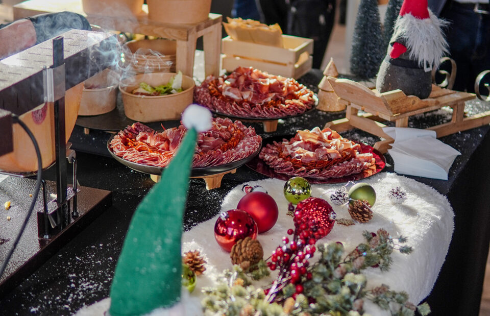 Raclette station with melted cheese and festive decor at Taste Corner’s Christmas event in South Florida