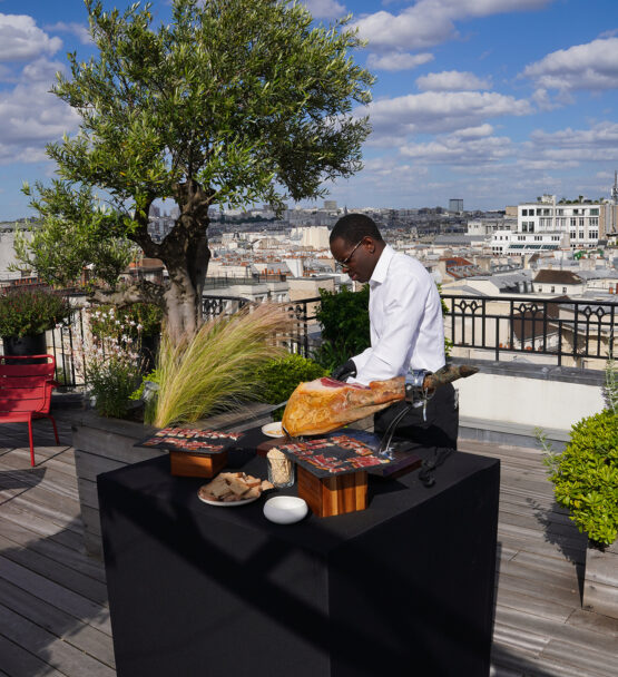 Chef carving ham at Taste Corner’s rooftop station during an elegant catered event in South Florida