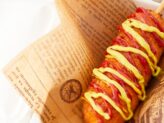 Freshly prepared corn dog ready to be enjoyed at Taste Corner’s catering station during an event