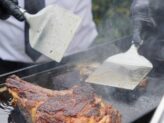 Chef grilling ribeye steaks at Taste Corner’s scenographic BBQ station during a catered event in South Florida