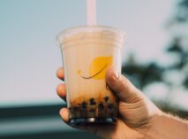 Person holding a bubble tea at Taste Corner’s event with toppings drink station in South Florida