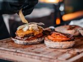 Chef preparing a gourmet burger at Taste Corner’s scenographic burger station during a catered event in South Florida