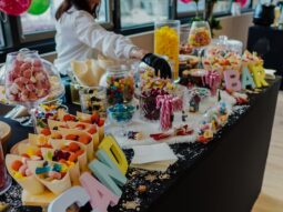 Candy station with host handing out sweets at Taste Corner’s scenographic Christmas buffet during a festive event in South Florida
