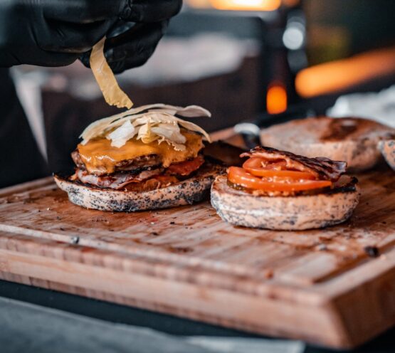 Chef preparing a gourmet burger at Taste Corner’s scenographic burger station during a catered event in South Florida