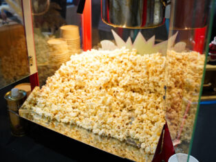 Popcorn machine popping kernels live at Taste Corner’s scenographic station during a catered event in South Florida