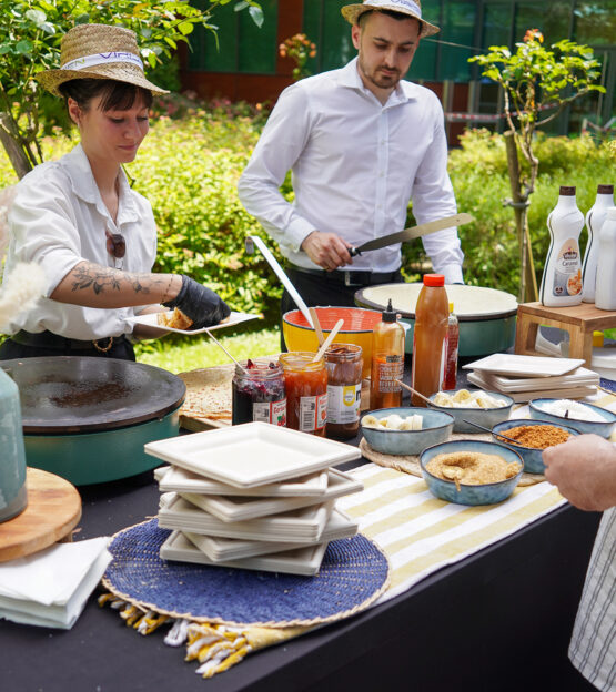 Chefs preparing crêpes with assorted toppings and syrups at Taste Corner’s live station during a catered event in South Florida