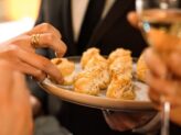 Server offering hors d'oeuvre bites to guests during an elegant Taste Corner event in South Florida