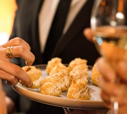 Server offering hors d'oeuvre bites to guests during an elegant Taste Corner event in South Florida
