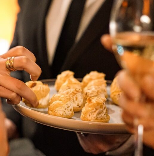 Server offering hors d'oeuvre bites to guests during an elegant Taste Corner event in South Florida