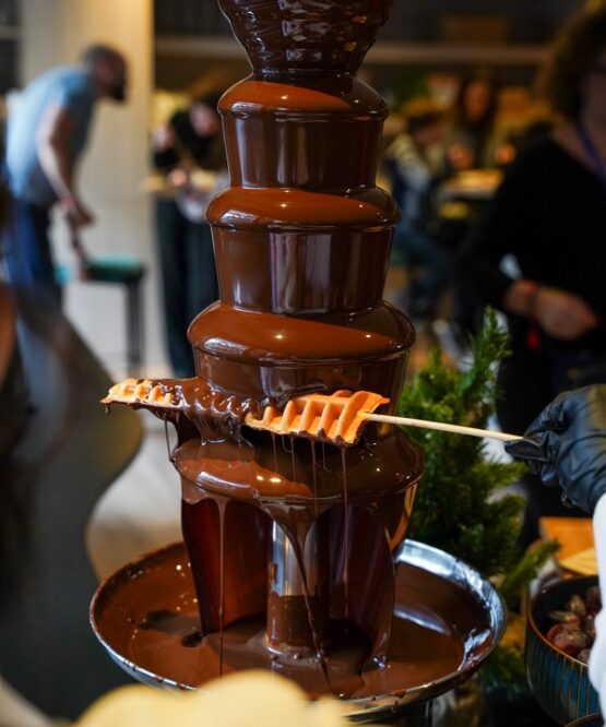 Chocolate fountain live station with chef preparing fresh fruit at Taste Corner event catering