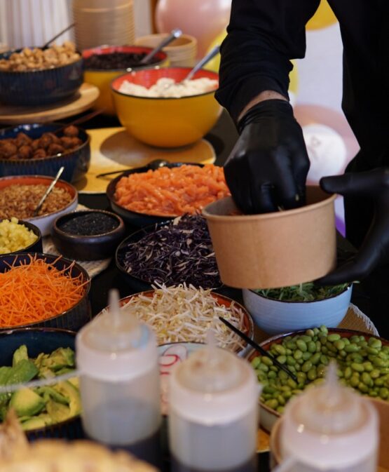Chef preparing poke bowls with fresh toppings at Taste Corner’s live station during a catered event in South Florida