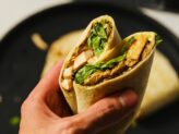 Guest holding a freshly prepared wrap from Taste Corner’s catering station