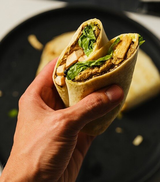 Guest holding a freshly prepared wrap from Taste Corner’s catering station